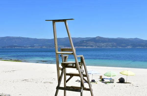 Pláž Dřevěnou Židlí Pro Záchranné Vesty Plážovými Deštníky Galicie Španělsko — Stock fotografie