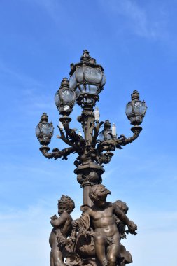 Pont Alexandre III detay, heykeller ve mavi gökyüzü ile bronz sokak lambası. Paris, Fransa.