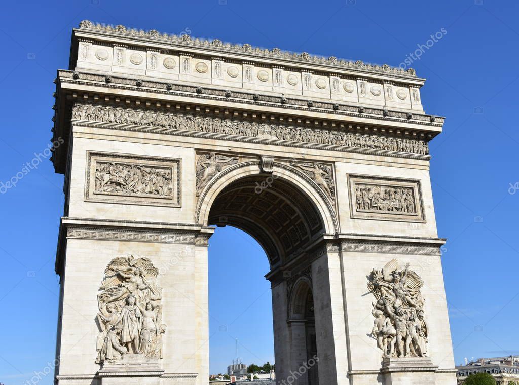 Arc de Triomphe close-up from Champs Elysees with blue sky. Paris, France.