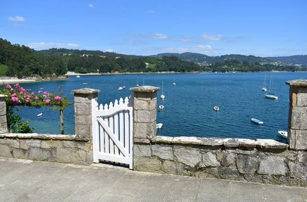 ボートやビーチと小さな漁村 白い木製のドアと花で表示します ガリシア スペイン — ストック写真