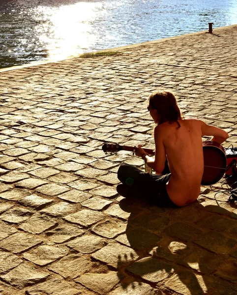 サンセット時にセーヌ川の川岸でアコースティックギターを弾いていた男 フランス 2018年8月14日 ロイヤリティフリーのストック画像
