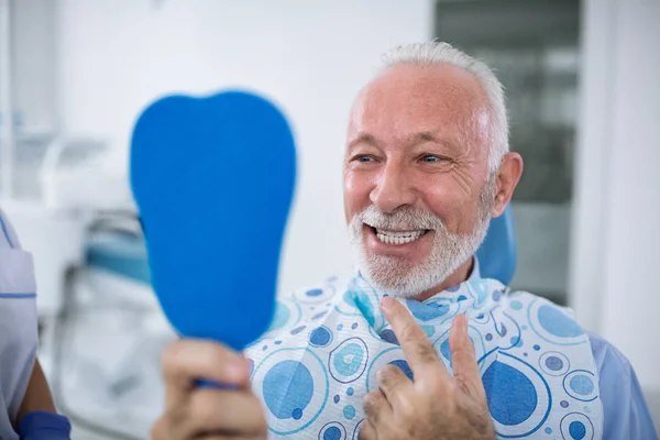 Pasien Yang Tersenyum Dan Puas Setelah Perawatan Melihat Gigi Cermin — Stok Foto