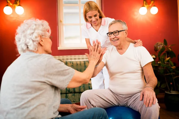 Glücklich Lächelnde Senioren Üben Gemeinsam Mit Krankenschwester Häusliches Behandlungskonzept — Stockfoto