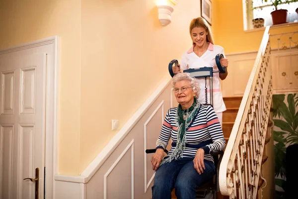 Sonriente Anciana Feliz Mientras Enfermera Ayuda Subir Las Escaleras Hogar — Foto de Stock