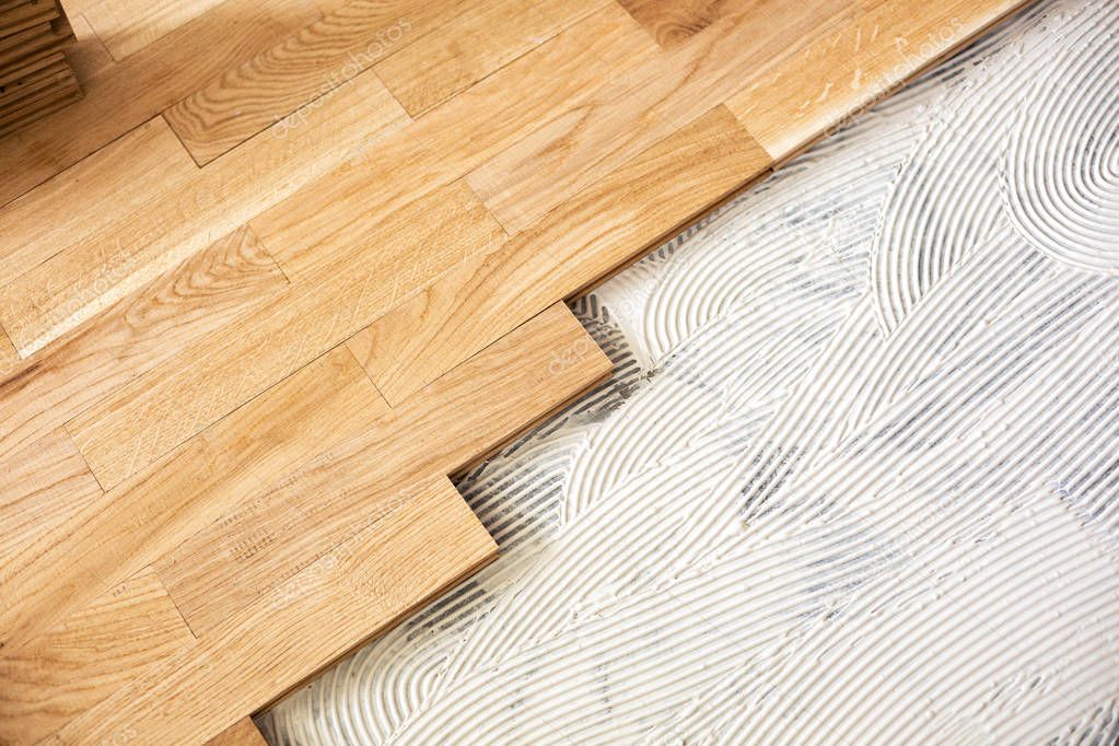 A closeup of subfloor mixture and assembled parquet plates in the working environment 