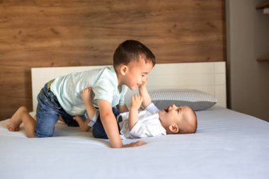 İki kardeş kanepede neşe ve neşeyle oynuyorlar. 