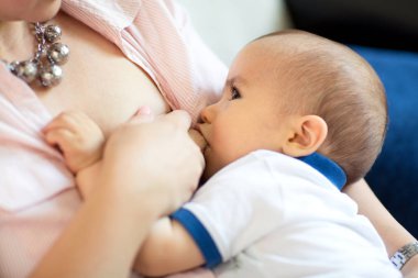 Onun küçük çocuk ve bağ bebek ile anne emzirme ihale