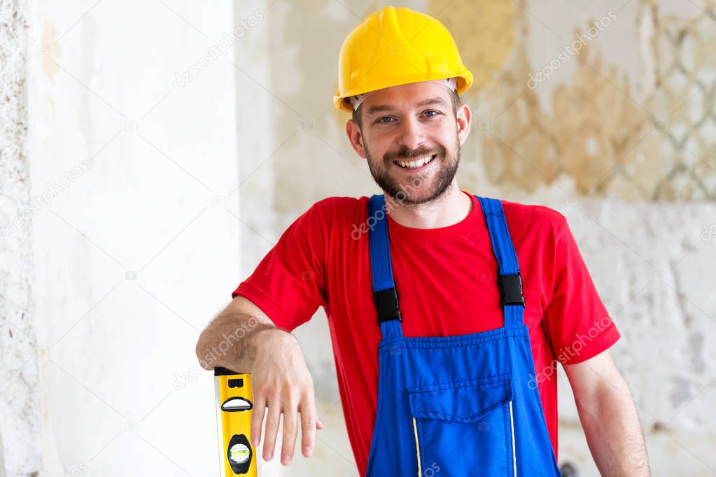 Building worker posing for a photo leaning on the end of a water level