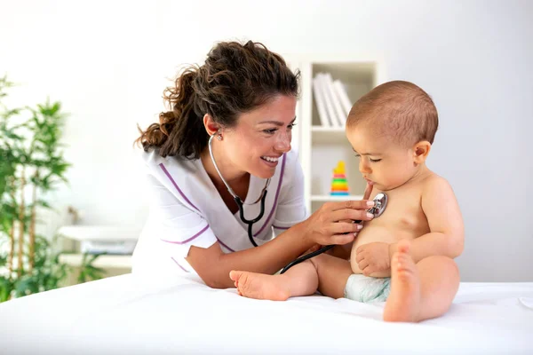 医生检查她的婴儿病人与听诊器 当婴儿坐直立在体检 — 图库照片