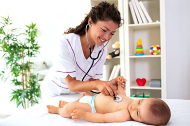 Onun doktoru onu bir standart tıbbi check-up sırasında inceler gibi onun arkasında yatan bebek
