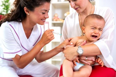 Little boy receiving a vaccine shot with disapproval expression on his face clipart
