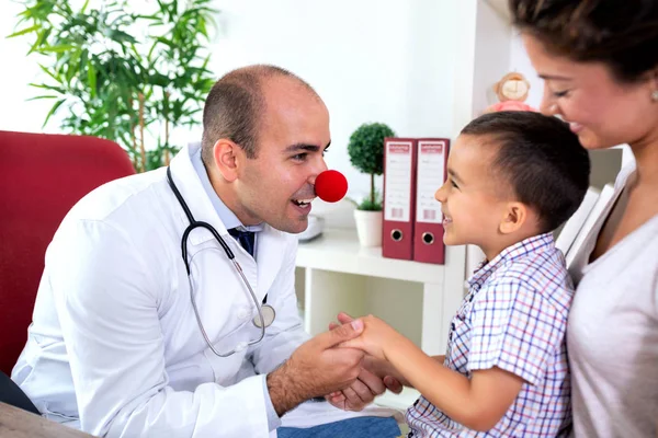 滑稽的医生穿着小丑鼻子娱乐他的病人和他的母亲 — 图库照片