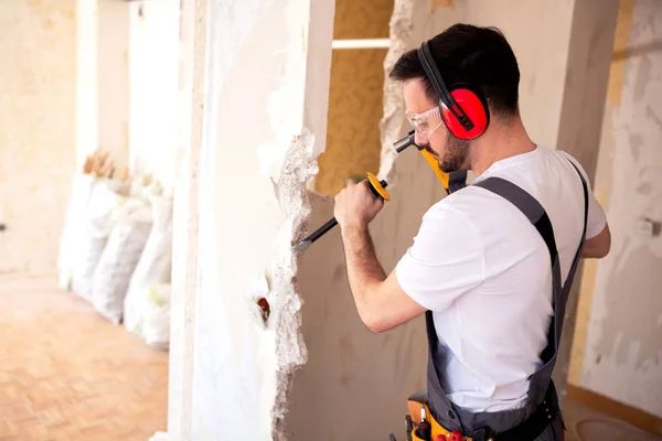 Trabajador Que Lleva Auriculares Protectores Rojos Usando Herramientas Pared Demolición —  Fotos de Stock