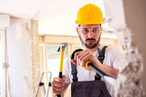 Tearing down a worn out wall with manual work tolls