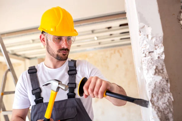 Tearing down a worn out wall with manual work tolls