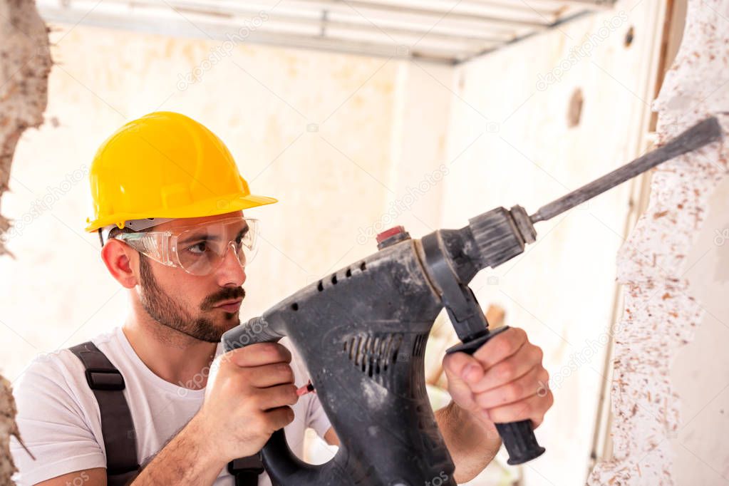 Chiseling of a concrete wall with powerful electric tools 