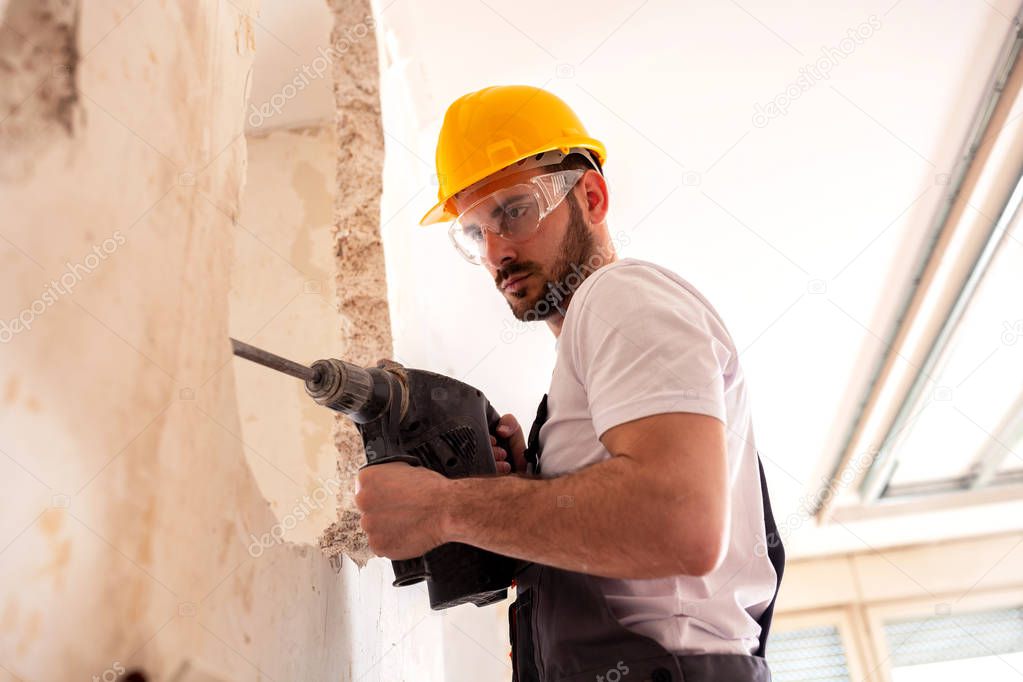 Chiseling of a concrete wall with powerful electric tools 