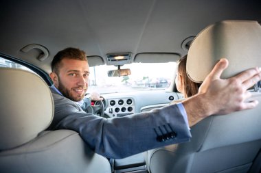 Yakışıklı adam arabayı ters doğrudan arabanın arka pencereden bakıyor