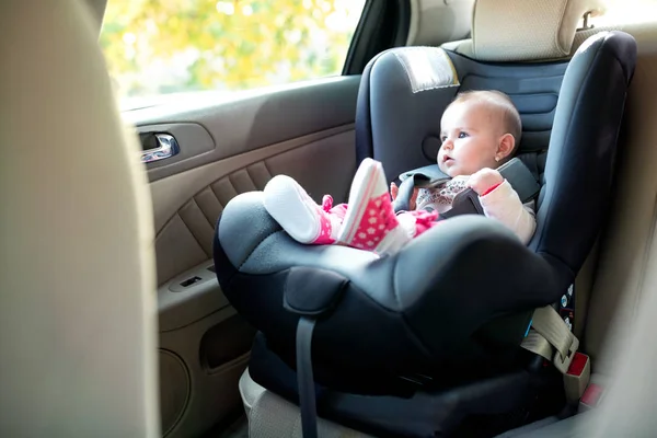 bébé fille de 4 mois assis dans un siège pour bébé avec des jouets regarder  à côté du jouet Photo Stock - Alamy