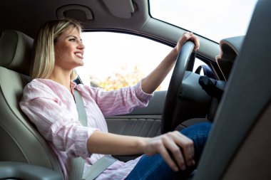 Güzel bir araba sürüş yüzünde kocaman bir gülümseme ile genç kız