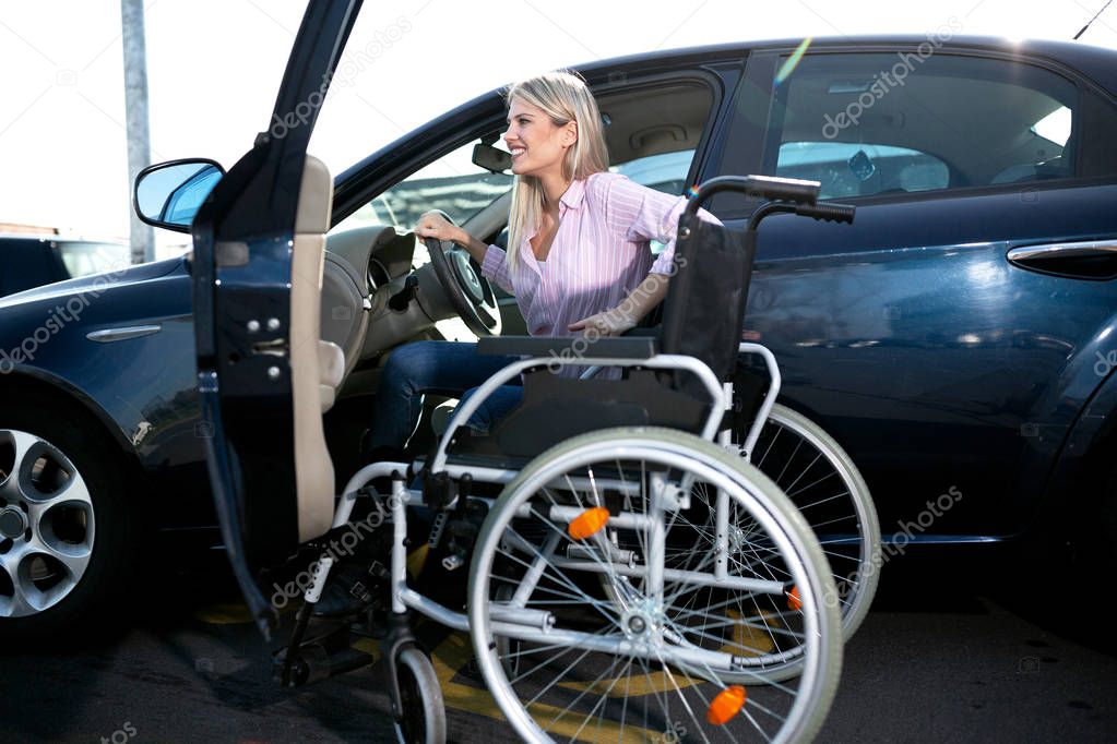 Blonde girl with loss of leg function sitting in the car on the parking space for disabled people