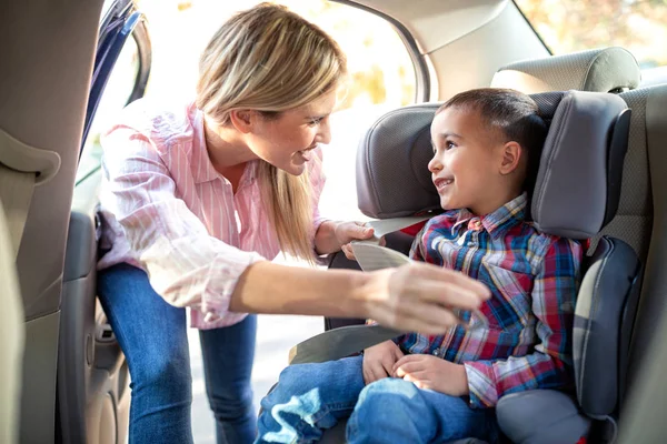 Responsible parent securing her child with a seatbelt, child car seat
