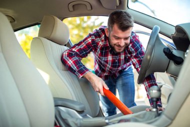 Genç adam araba tozdan Temizleme 