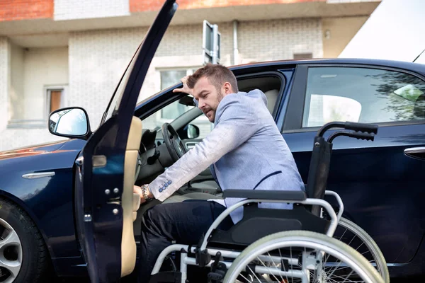 Man gör ett drag från sin rullstol till förarsätet — Stockfoto