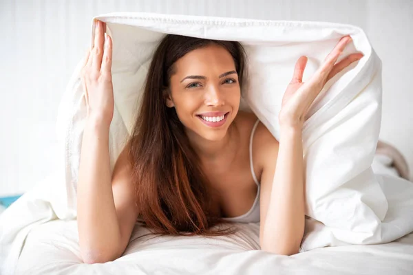 Foxy dama escondida y sonriendo bajo su sábana — Foto de Stock
