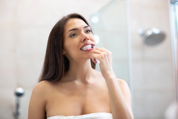 Очень красивая девушка с каштановыми волосами чистит зубы — стоковое фото