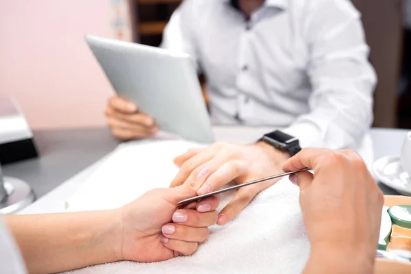 Man hands manicure treatment with emery board