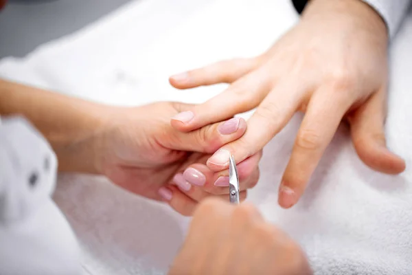 Manucure utilisant des ciseaux à cuticules pour le traitement des ongles — Photo