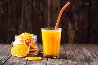 Turuncu smoothie ora dilimleri ile süslenmiş masada servis