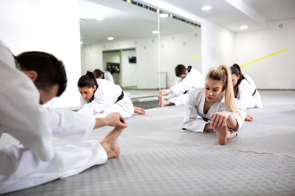 Kampartister gör bensplittringar medan värmer upp för taekwondo — Stockfoto