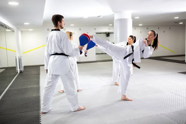 Två flickor utbildning Taekwondo och sparkar mål kuddar — Stockfoto