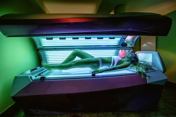 Menina bonita recebendo um bronzeado sunbed — Fotografia de Stock