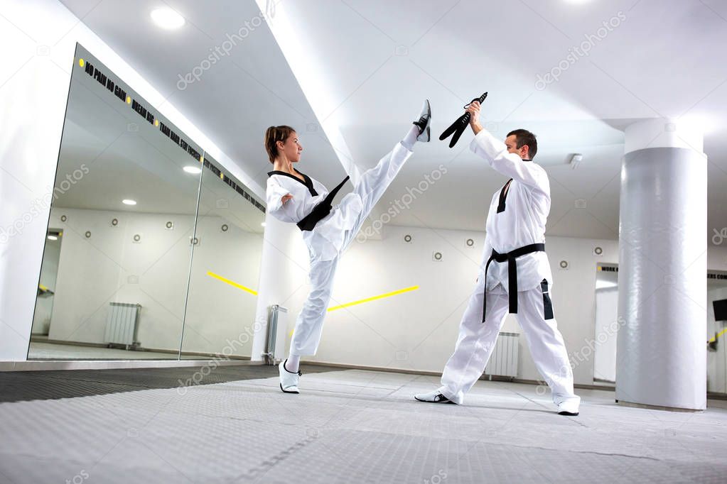 Physically challenged young woman in taekwondo practicing a high
