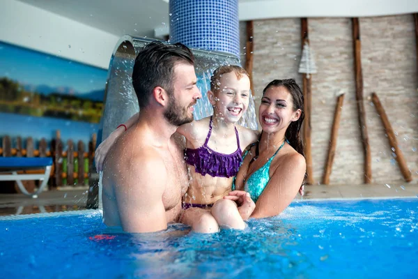 Padres felices con su hija en la piscina — Foto de Stock