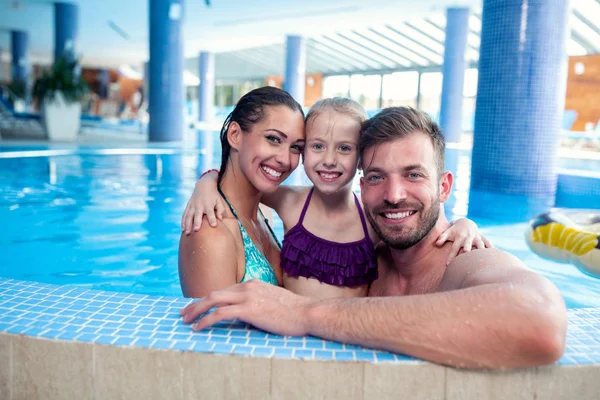 Familia feliz junto a la piscina — Foto de Stock