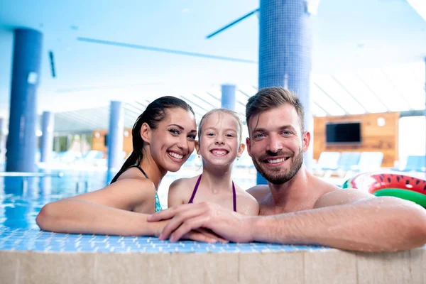 Familia feliz junto a la piscina — Foto de Stock