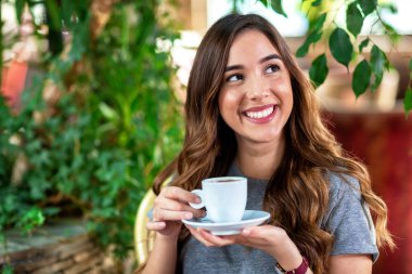 Güzel genç kadın bir kahve ve gülümseyen sahip