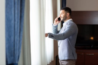 Keskin giyimli işadamı telefonda konuşuyor