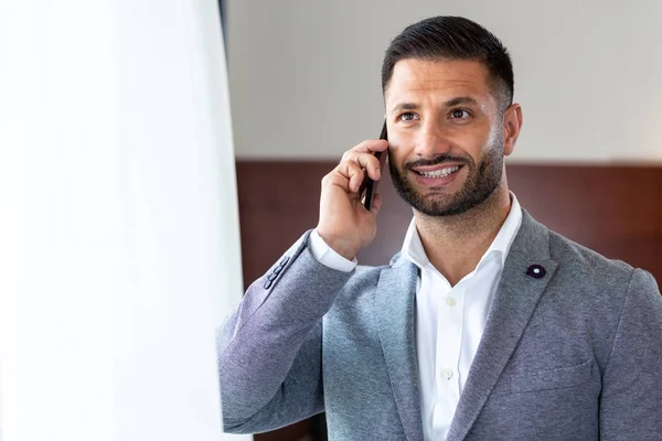 Hombre de negocios guapo a través del teléfono móvil — Foto de Stock
