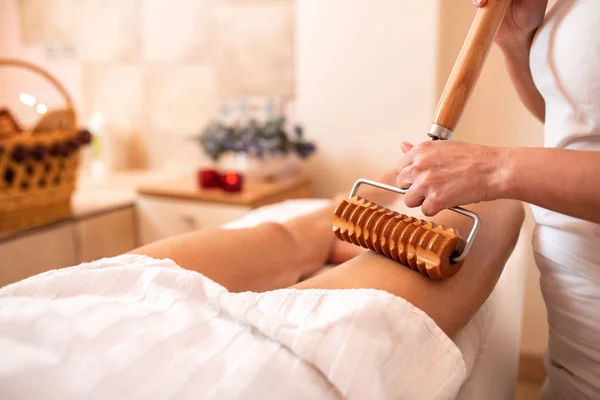 Terapia anti-celulite com uma ferramenta de rolo de madeira estendida — Fotografia de Stock