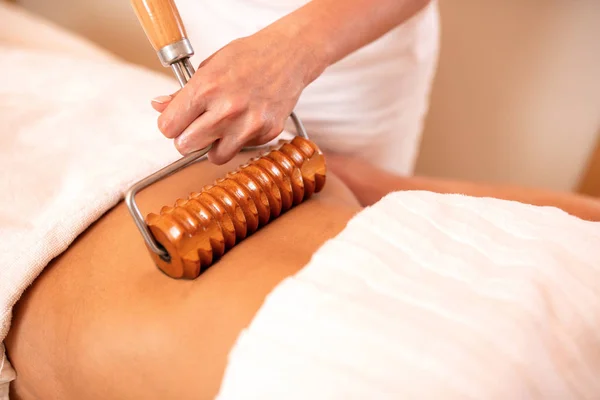 Rolo de madeira com alça estendida aplicada em massagem corporal — Fotografia de Stock