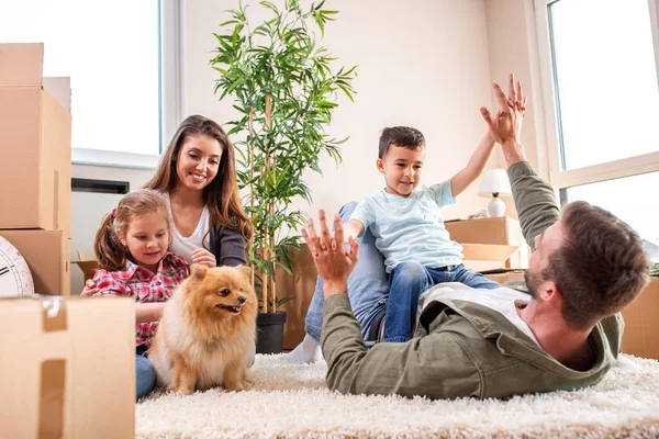 Mama, Papa, ihre Kinder und ihr Hund ziehen in die neue Wohnung ein — Stockfoto