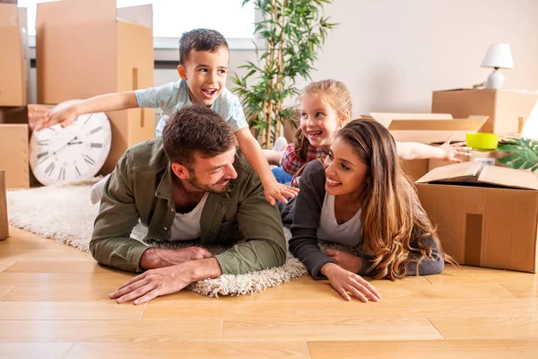 Glückliche Kinder auf dem Rücken ihrer Eltern — Stockfoto