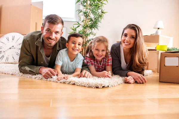 Familie entspannt auf dem Teppich in ihrer neuen Wohnung — Stockfoto