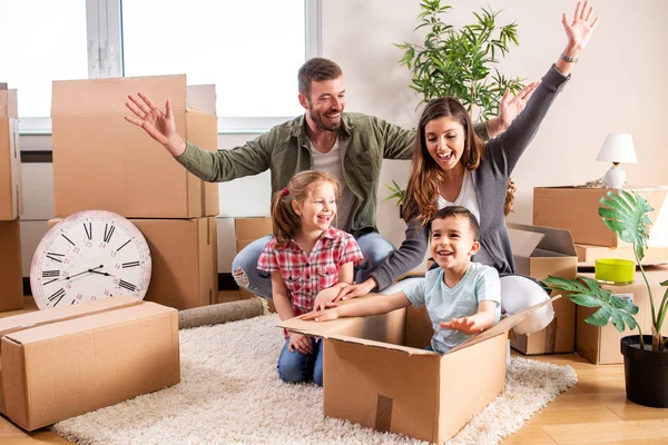 Happy family moving in their new home and having a playtime with — Stock Photo, Image