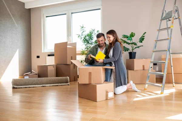 Feliz pareja desempacando cajas en su nuevo apartamento —  Fotos de Stock